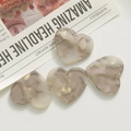 Macro shot of marble textured heart charms in pearl acrylic for DIY jewelry making - Gray