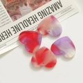 Macro detail of marbled acrylic heart charms with vibrant red and purple swirls for DIY crafts - Red