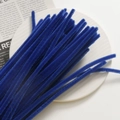 Close-up of dark blue fuzzy pipe cleaners for DIY floral crafts on a white ceramic plate - Dark Blue
