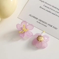 Detailansicht der lavendelfarbenen Orchideen-Ohrringe mit Harzblättern und gelben Staubbeuteln - Lila