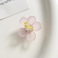 Detalle de flor de cerezo rosa de acrílico con centro amarillo sobre bandeja de cerámica - Rosa Claro