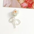 Detail eines handgefertigten Tulpen-Anhängers mit orangen und klaren Glasperlen - Weiß & Orange
