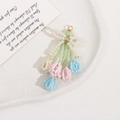 Detail of beaded tassel bow charm with pastel macaron flower buds and golden hook - Bouquet Style