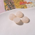 Detail of 12mm semi-translucent jelly resin cabochons on a white textured plate - Off-white