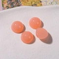 Detailed macro of 12mm translucent pink resin cabochons for DIY jewelry making - Orange