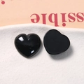 Close-up of polished black resin heart charms with flat back for DIY jewelry making - Black
