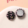 Macro-opname van roze en zwarte ronde tweed knopen met zilverdraad voor DIY naaiwerk - Rond Zwart-Roze