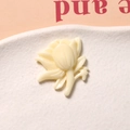 Macro shot of cream resin floral charm detail for DIY jewelry on a white tray - Daisy Flower Style