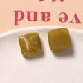 Detalle macro de componentes de resina para pendientes cuadrados con textura de mármol verde - Verde oliva