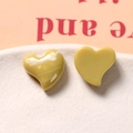 Macro shot of glossy mustard yellow resin heart accessories with marble texture details - Yellow Green One