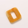 Close-up of caramel square resin charm with amber texture and hole for DIY jewelry - Caramel color