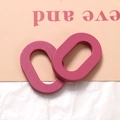 Makroaufnahme magentafarbener ovaler Holzanhaenger mit feiner Maserung fuer DIY-Schmuck - Rosa
