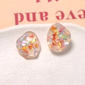 Macro shot of irregular pebble-shaped resin earrings with colorful iridescent sequins - Glitter Sequin Irregular Style