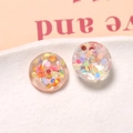 Dettaglio di ciondoli tondi in resina con paillettes laser per la creazione di gioielli - Stile Rotondo con Paillettes Scintillanti