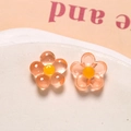 Macro shot of orange translucent resin flower charms with smooth jelly texture for DIY crafts - Pink