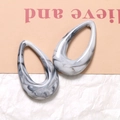 Macro shot of resin teardrop earrings with black and white ink marble texture - Smoke