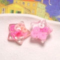Dettaglio ravvicinato di stelle in resina trasparente con coriandoli colorati interni - Rosa
