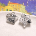Detailed view of clear resin star charms with black and white disc inlays for DIY jewelry - Smoke