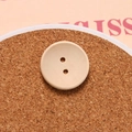 Macro shot of a round concave two-hole wooden button for sewing and DIY crafts - Bowl Shaped Concave Two Holes Style / Natural Wood Color
