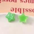 Dettaglio macro di ciondoli a stella in resina verde lime traslucida con glitter argento - Verde