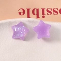 Vista macro di ciondoli a stella in resina viola traslucida con glitter iridescenti - Viola