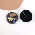 Dettaglio macro del cabochon in resina con stelle dorate e glitter cosmici - Stile Semicircolare Pianeta
