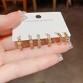 Macro-opname van drie paar goudkleurige hartjes oorbellen met zirkonia op een displaykaart - Gouden Zirconia Hart Stijl (14)