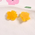 Primo piano di toppe in resina gialla a forma di fiori per gioielli e artigianato DIY - Arancione