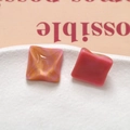 Macro detail of square water ripple resin charms with pink and gold glitter textures - Pink