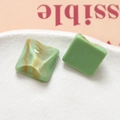 Macro shot of square green resin charms with gold marble texture for jewelry DIY - Green