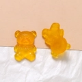 Detail of two amber yellow resin bear charms with engraved details for DIY crafts - Orange