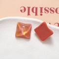 Macro detail of square resin charms with pink and gold glitter ripple texture for DIY crafts - Orange Pink
