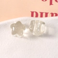 Dettaglio macro di ciondoli in resina glitterata a stella e zampa su vassoio bianco - Bianco Trasparente
