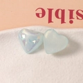 Primer plano de dijes de resina en forma de corazón con purpurina azul e iridiscente - Azul