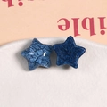 Dettaglio macro di accessori a stella in resina blu scuro con finitura crepata e glitter - Blu Nebbia