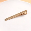 Detailed close-up of a minimalist gold polished metal duckbill hair clip with anti-slip teeth - Thin Duckbill Clip