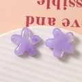 Macro shot of purple translucent resin flower charms with marble texture on ceramic tray - Purple
