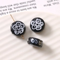 Macro detail of black glass beads with white plum blossoms and side holes for DIY jewelry - Plum Blossom