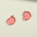 Primer plano de dijes de melocotón de resina rosa translúcida con agujeros para joyería DIY - Melocotón