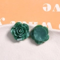 Vista macro di ciondoli a rosa in resina marmorizzata verde su piatto di ceramica - Verde Scuro