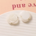 Macro view of white resin rose charms showing detailed petals for DIY jewelry making - White