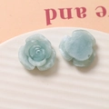 Macro detail of resin rose flower charms in light green marble texture on a white tray - Mint Green