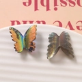 Dettaglio di ciondoli a farfalla in resina AB iridescente su vassoio in ceramica bianco - Nero (Aurora)