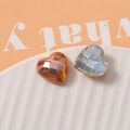 Macro shot of geometric faceted heart charms in metallic and pearlescent finishes - Orange