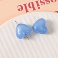 Details von blauen Herz-Harzperlen mit Glitzer und Goldnadel auf weißem Tellerrand - Dunkelblau