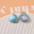 Macro shot of light blue pearlescent heart charms with internal grid texture - Blue