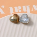 Macro detail of geometric heart charms with iridescent white and metallic gold finish - Brown