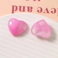 Macro detail of heart-shaped pink resin charms with marble texture on a ceramic plate - Pink
