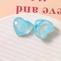 Detail of blue marble texture resin heart charms on a ceramic plate for DIY jewelry making - Blue