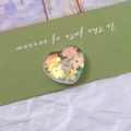 Macro shot of iridescent heart-shaped resin charm with orange flower patterns for DIY crafts - Heart Style